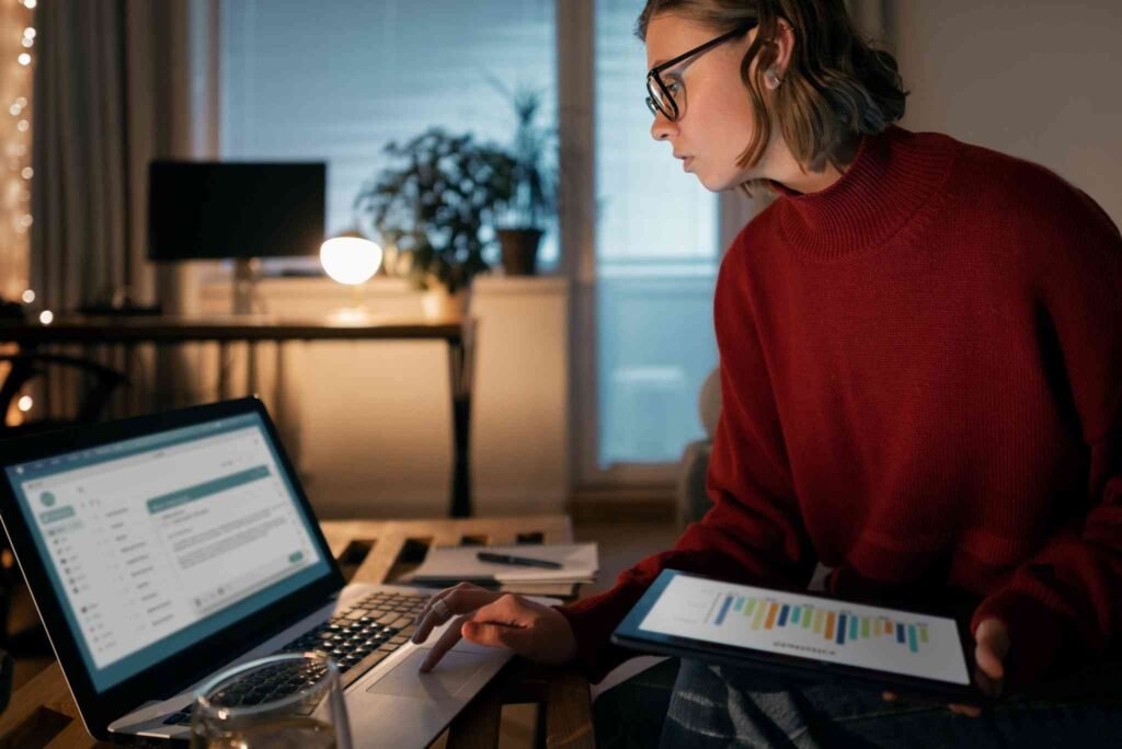 A millennial thoughtfully looking at financial charts on a laptop, emphasizing smart financial planning with term life insurance millennials.