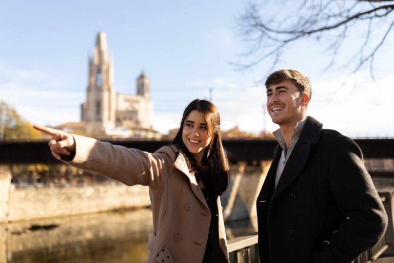 "A young British couple, smiling and holding hands, walking through a modern urban park, representing early financial planning and UK lifestyle life insurance."