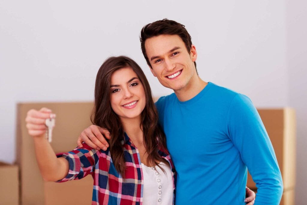 Happy couple with new house keys, emphasizing the joy of Homebuyer Life Insurance UK protection.